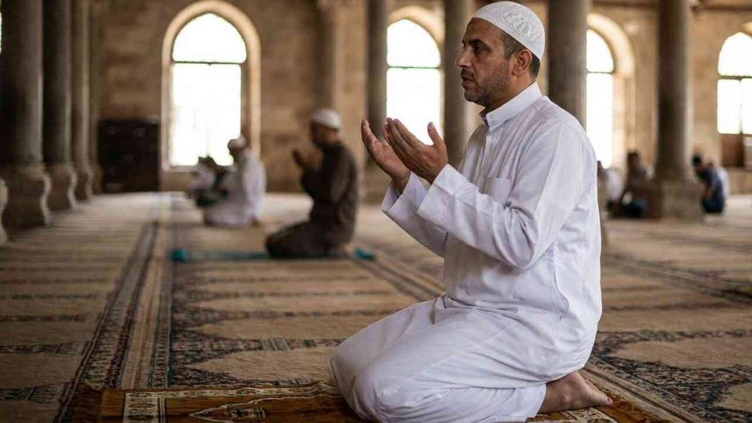 man praying at the mosque with both hands facing upwards